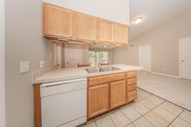kitchen featuring white dishwasher, a sink, light colored carpet, light brown cabinets, and light tile patterned floors