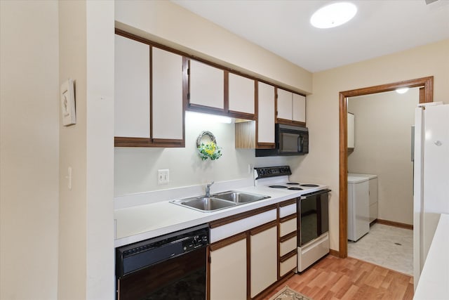 kitchen with black appliances, a sink, independent washer and dryer, light countertops, and white cabinetry