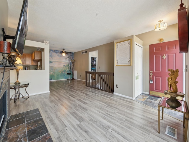 49559 Donovan Blvd, Plymouth, MI 48170 - foyer with wood finished floors, a ceiling fan, baseboards, a textured ceiling, and a fireplace