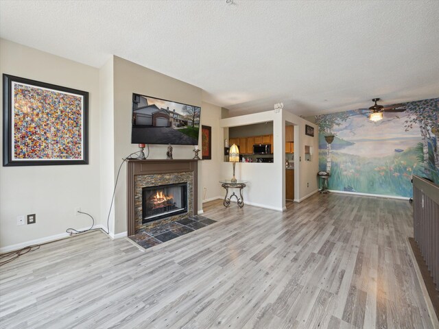 49559 Donovan Blvd, Plymouth, MI 48170 - unfurnished living room with a stone fireplace, wood finished floors, a ceiling fan, baseboards, and a textured ceiling