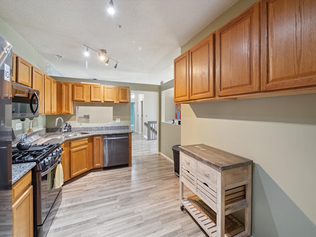 49559 Donovan Blvd, Plymouth, MI 48170 - kitchen with appliances with stainless steel finishes, a sink, light wood-style floors, dark stone counters, and brown cabinetry