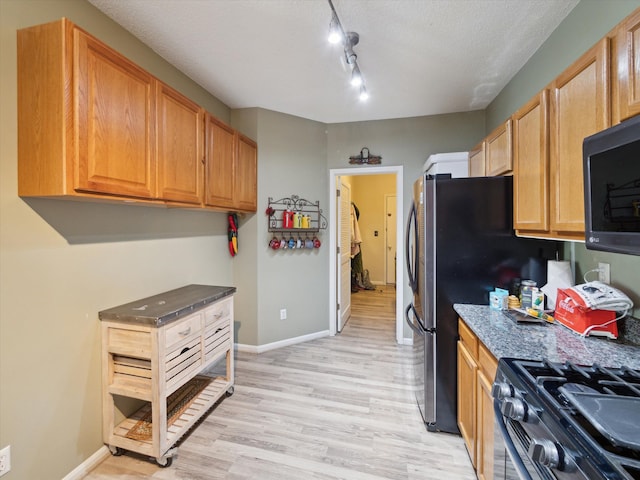 49559 Donovan Blvd, Plymouth, MI 48170 - kitchen with light wood-style flooring, gas stove, baseboards, rail lighting, and a textured ceiling