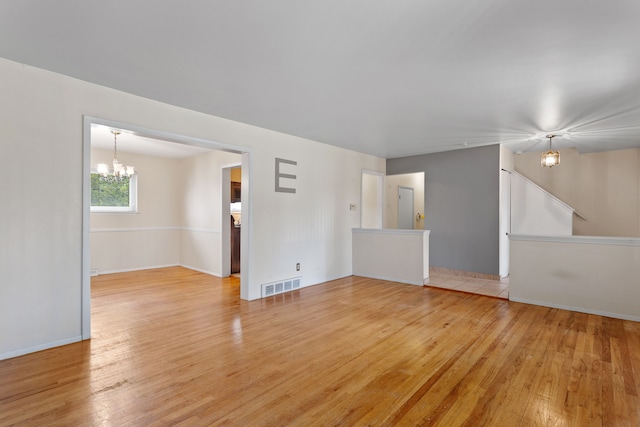 29458 Walker Dr, Warren, MI 48092 - unfurnished living room featuring a chandelier, light wood-style flooring, and baseboards