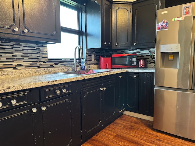 752 E Philadelphia Blvd, Flint, MI 48505 - kitchen featuring stainless steel fridge with ice dispenser, dark cabinetry, and backsplash