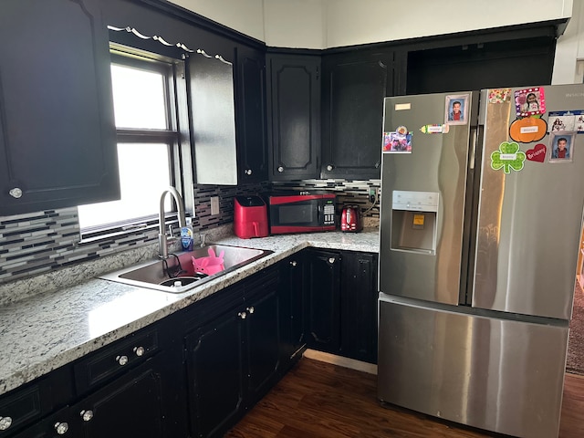752 E Philadelphia Blvd, Flint, MI 48505 - kitchen featuring stainless steel fridge with ice dispenser, a sink, decorative backsplash, and light countertops