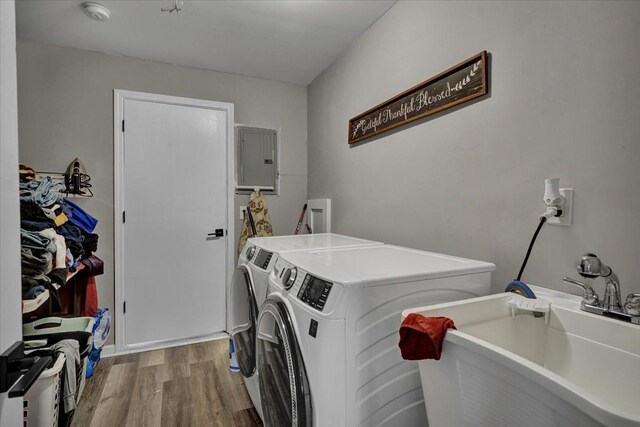 washroom featuring independent washer and dryer, light wood finished floors, and electric panel