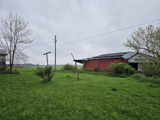 7697 Hogan Rd, Muir, MI 48860 - view of green lawn featuring an outbuilding and a pole building