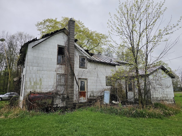 7697 Hogan Rd, Muir, MI 48860 - rear view of property featuring a chimney and a yard
