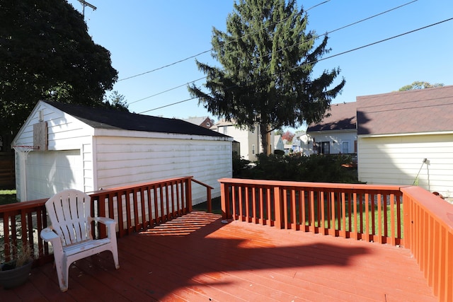 wooden deck featuring a detached garage and an outdoor structure