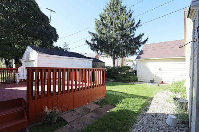 view of grassy yard with a deck and an outbuilding