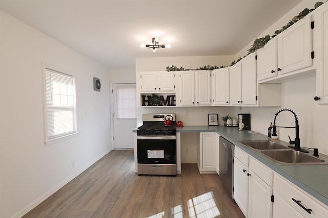 kitchen featuring appliances with stainless steel finishes, a sink, white cabinets, and dark wood-type flooring