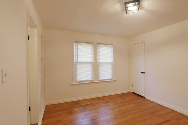 empty room with light wood finished floors and baseboards