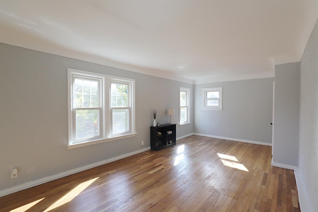 unfurnished living room featuring wood finished floors and baseboards