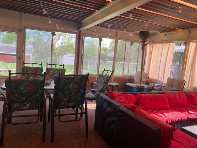 sunroom with outdoor lounge area, healthy amount of natural light, and carpet flooring