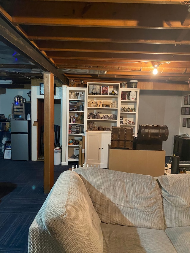 unfinished below grade area with refrigerator and carpet flooring