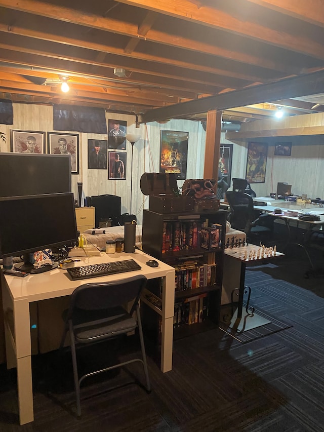 carpeted office space featuring wood walls