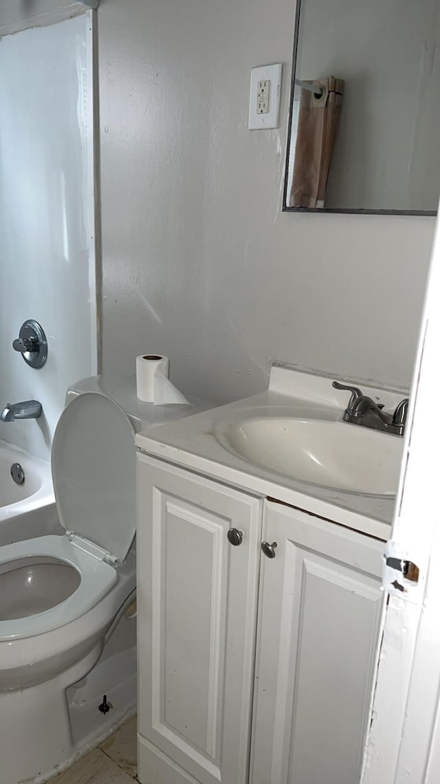 bathroom featuring toilet, vanity, and bathtub / shower combination
