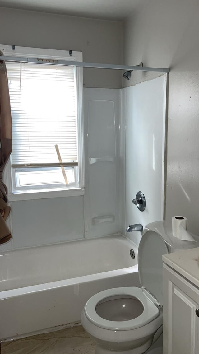 bathroom featuring toilet, plenty of natural light,  shower combination, and vanity