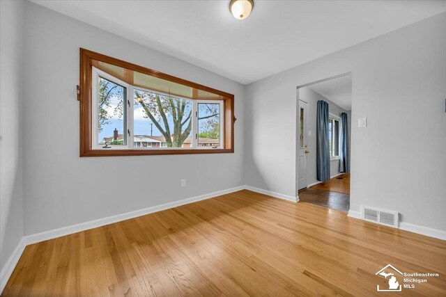 unfurnished room with baseboards and wood finished floors