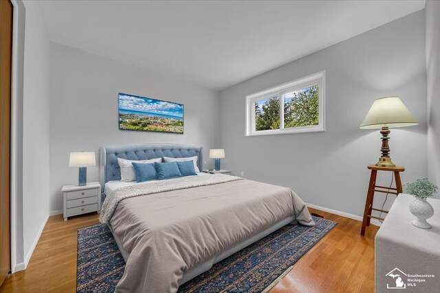 bedroom featuring light wood finished floors and baseboards