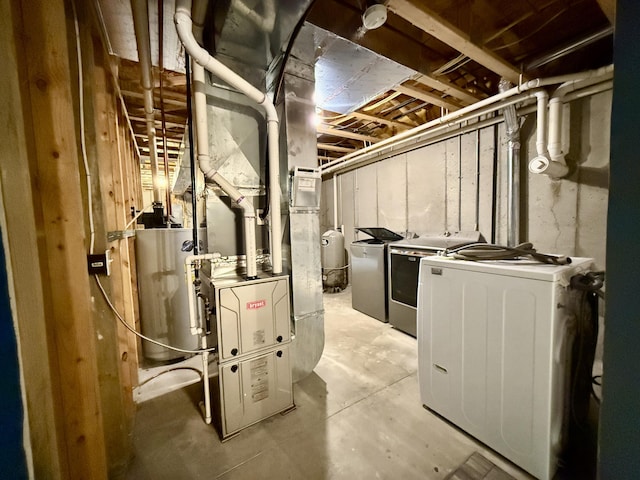 unfinished basement with washer and clothes dryer, water heater, and a water pressure tank