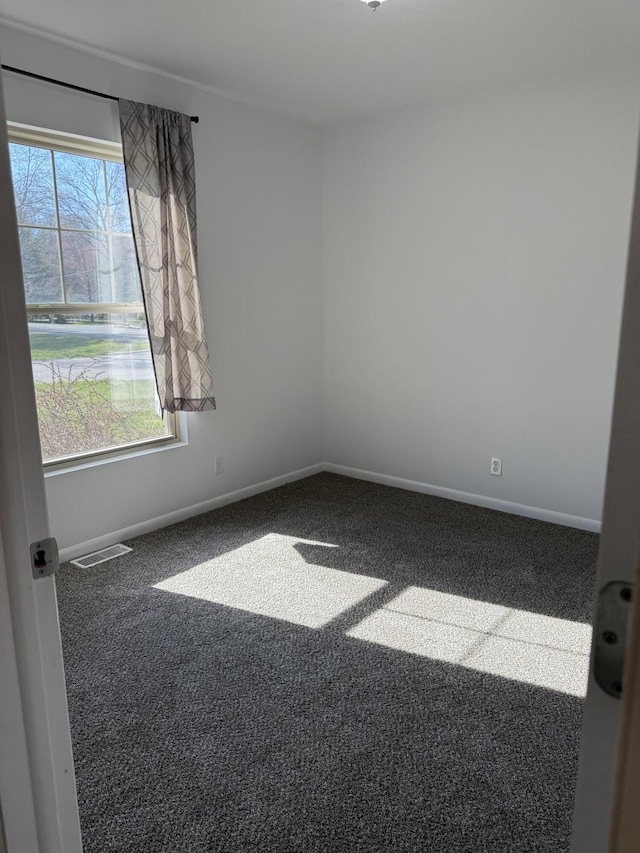 carpeted spare room featuring baseboards
