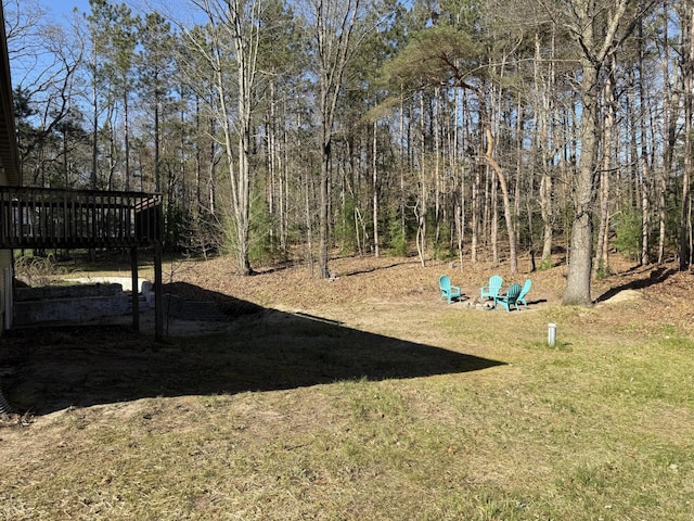 view of green lawn with a wooden deck and a detached carport