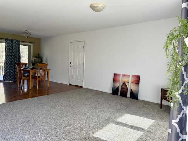living area featuring carpet flooring and baseboards