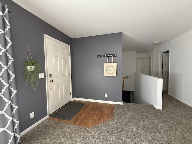 foyer featuring carpet floors and baseboards