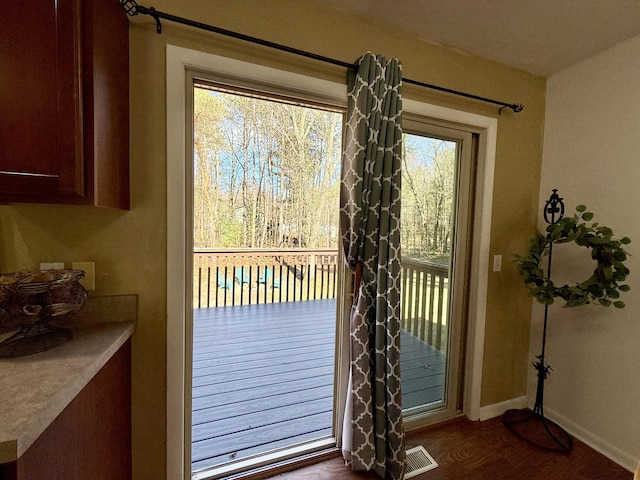 doorway to outside with dark wood-type flooring and baseboards