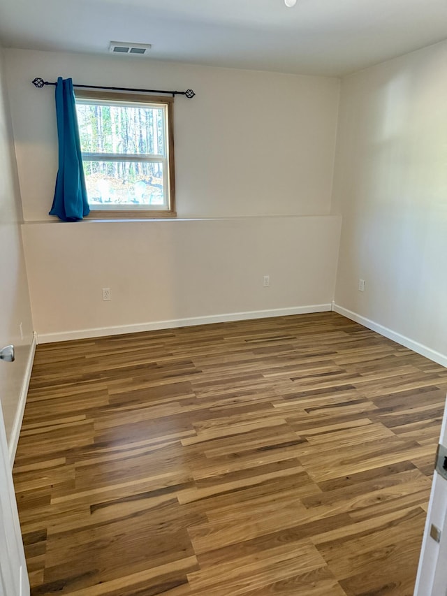 empty room with wood finished floors and baseboards