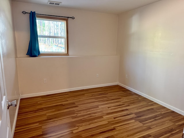 empty room featuring wood finished floors and baseboards