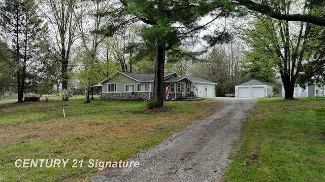 ranch-style home featuring a detached garage and a front yard