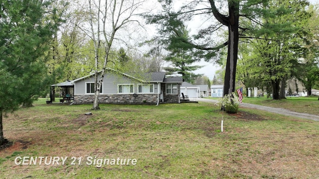 bungalow-style home with stone siding and a front yard