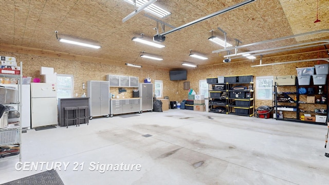 garage featuring freestanding refrigerator and a garage door opener
