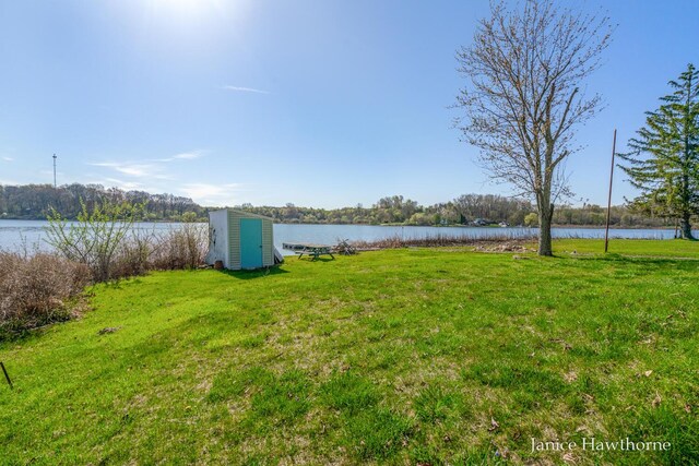 view of green lawn with a water view