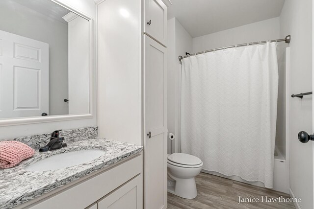 full bathroom featuring wood finished floors, vanity, toilet, and shower / bath combo