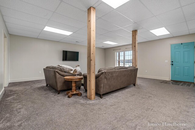 living area featuring a paneled ceiling, carpet flooring, and baseboards