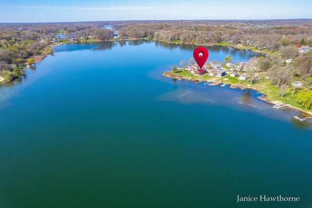 view of property location with a nearby body of water and a forest