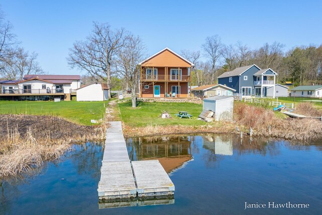 dock featuring a water view, a lawn, and a balcony