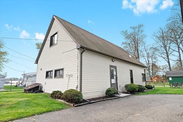 view of side of property with roof with shingles