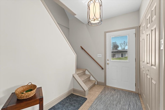doorway with light tile patterned floors, stairs, and baseboards
