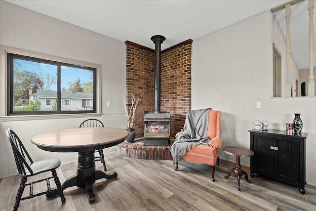 dining area featuring a wood stove and wood finished floors