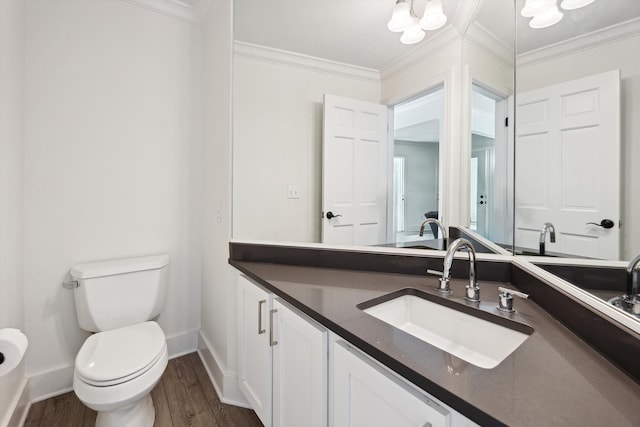 bathroom featuring ornamental molding, toilet, baseboards, wood finished floors, and vanity