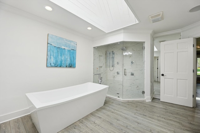 bathroom with ornamental molding, a marble finish shower, wood finished floors, a freestanding tub, and recessed lighting