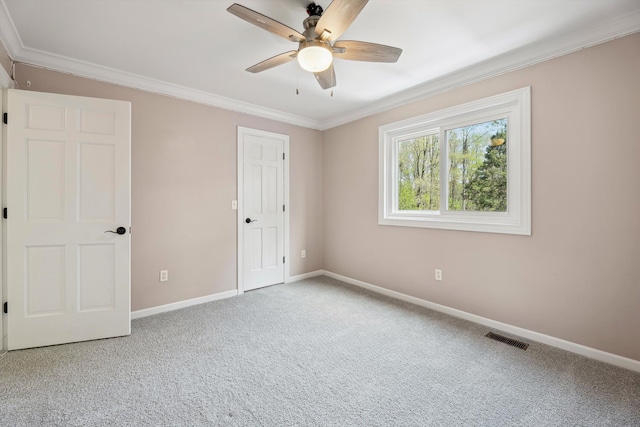 unfurnished bedroom featuring ornamental molding, baseboards, carpet flooring, and a ceiling fan