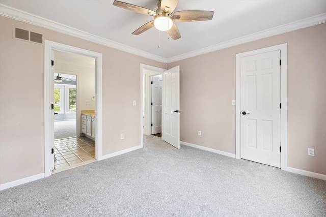 unfurnished bedroom featuring light carpet, crown molding, baseboards, connected bathroom, and a ceiling fan