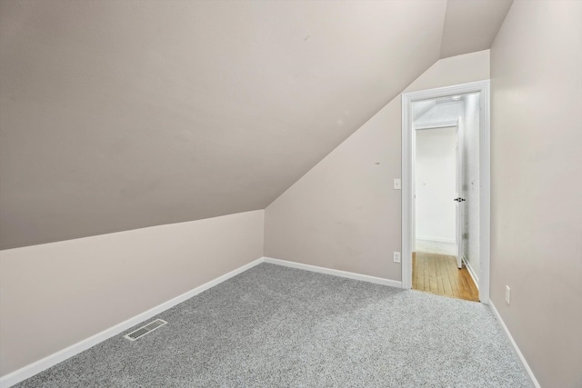 additional living space with lofted ceiling, carpet flooring, and baseboards