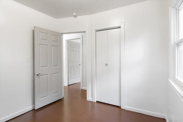12855 Couwlier Ave, Warren, MI 48089 - unfurnished bedroom featuring a closet, baseboards, and finished concrete flooring
