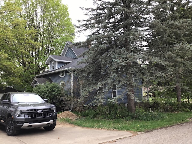 view of side of home with a shingled roof